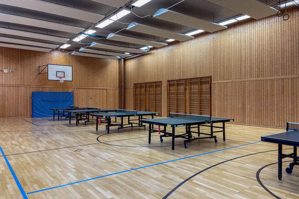 Innenansicht der sanierten Sporthalle mit aufgebauten Tischtennistischen